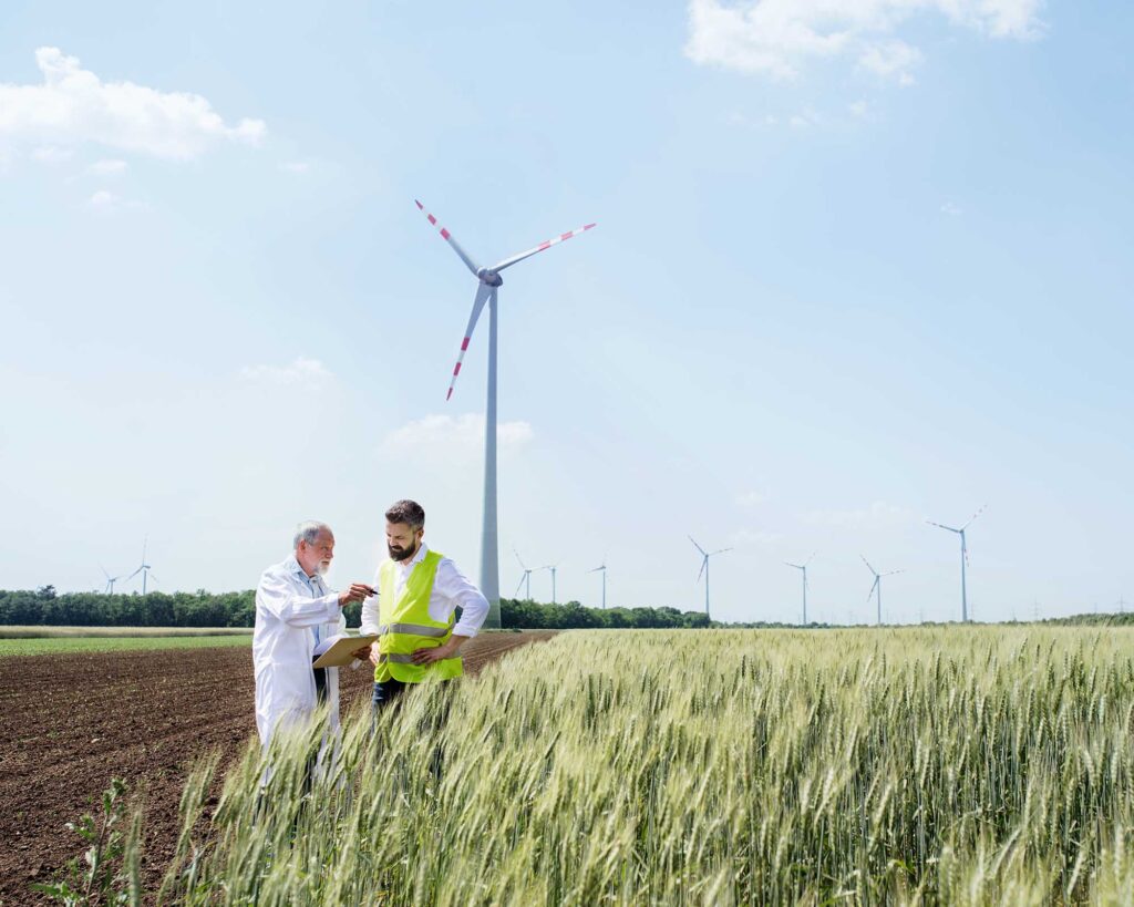 engineers-standing-on-wind-farm-making-notes-YSY6F6W.jpg